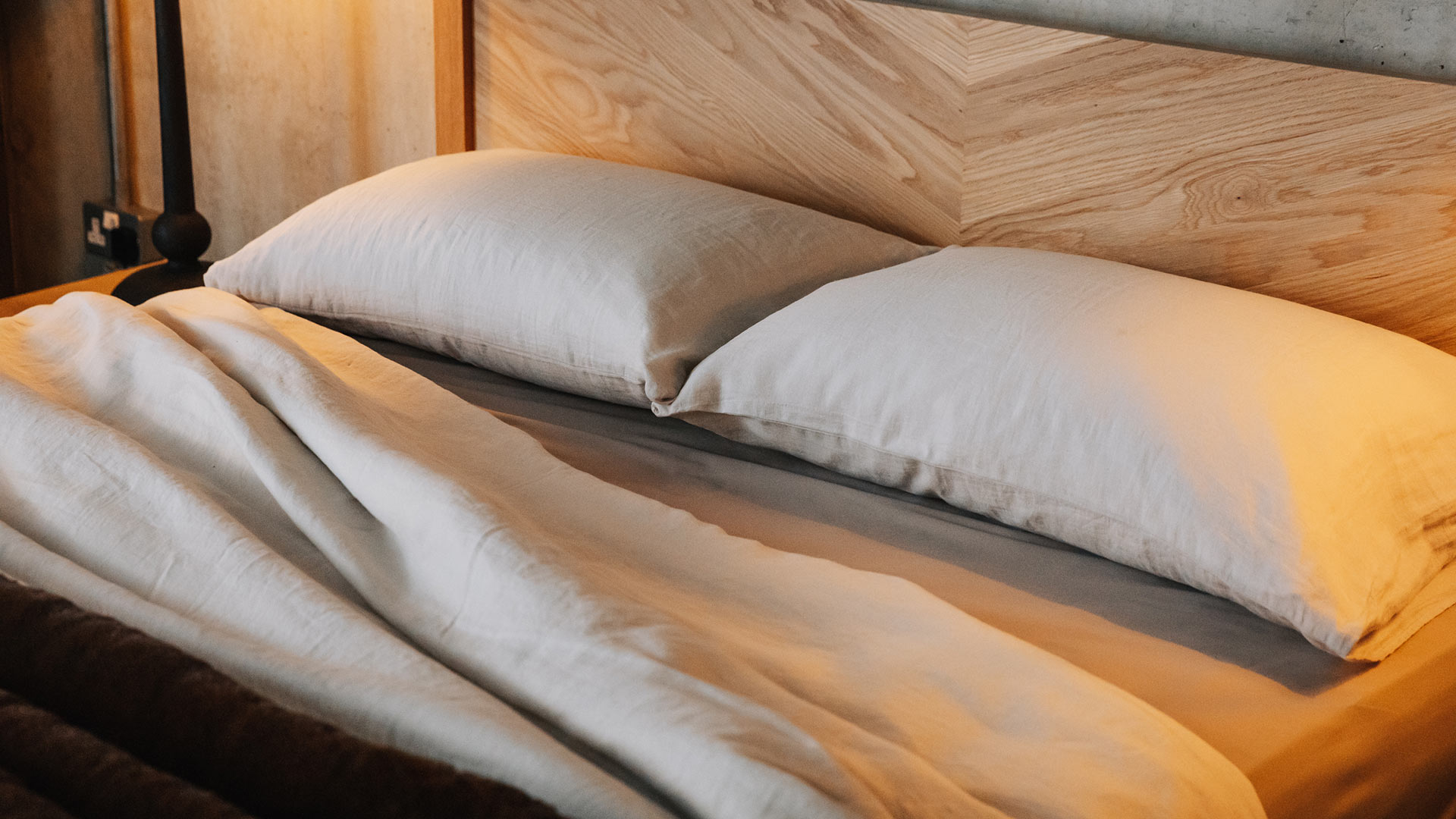 Detalle de textiles de lino y madera natural en un dormitorio de estilo escandinavo